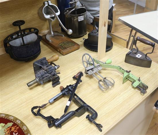 Two late Victorian cast iron tongue presses, an iron sausage maker, a hot iron & stand, a hand whisk,